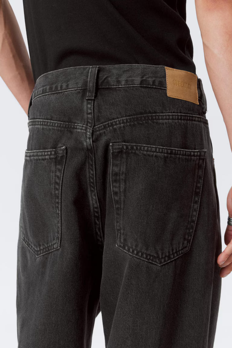 Black jeans with a brand label on a white background