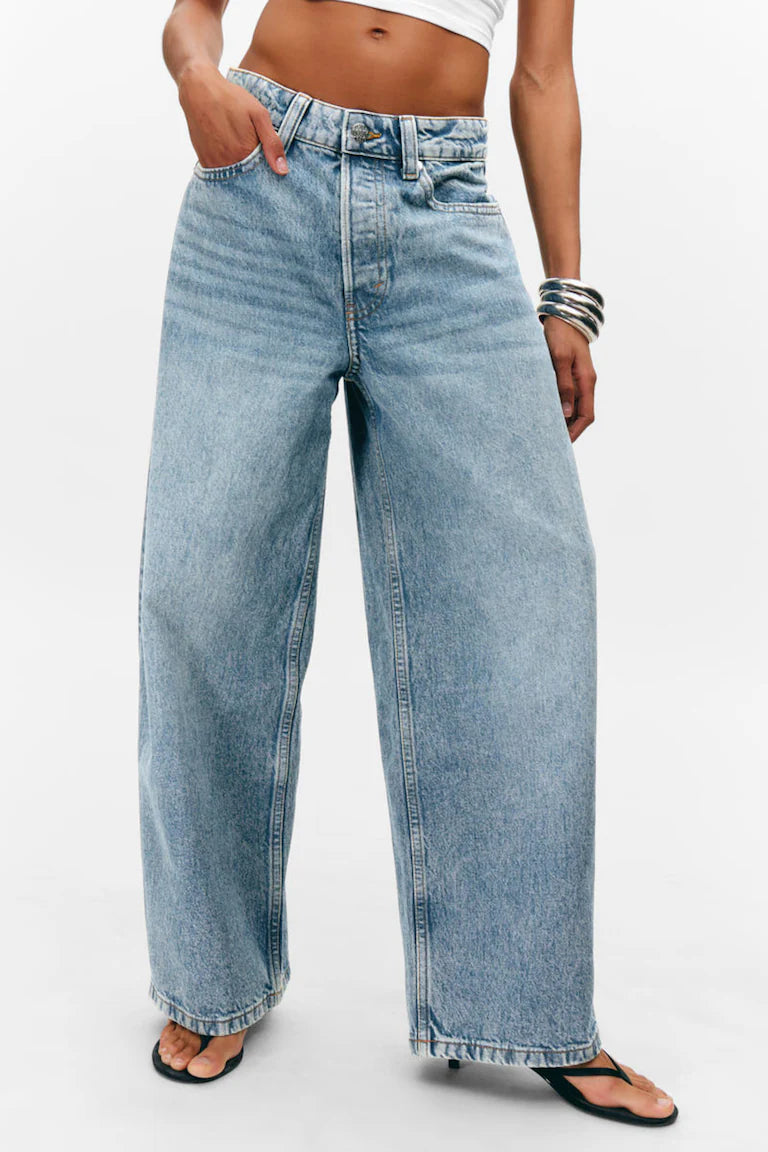 Person wearing light blue jeans on a white background