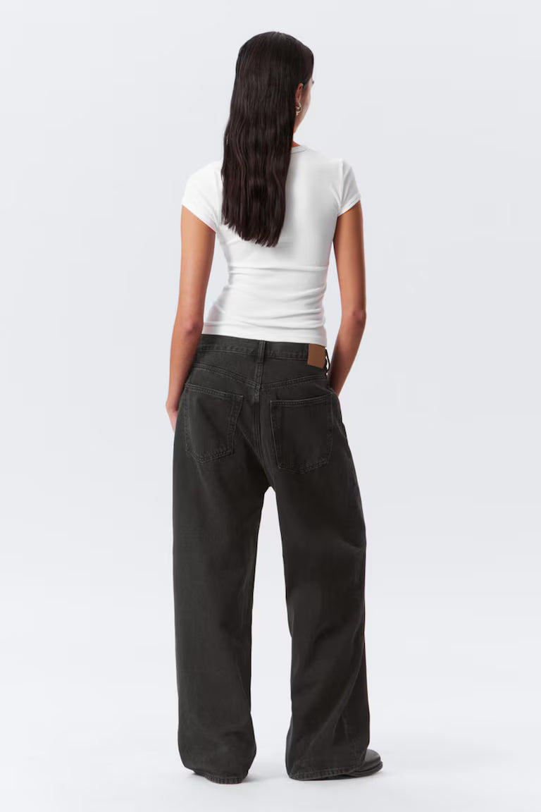 Person wearing a white t-shirt and black pants on a white background