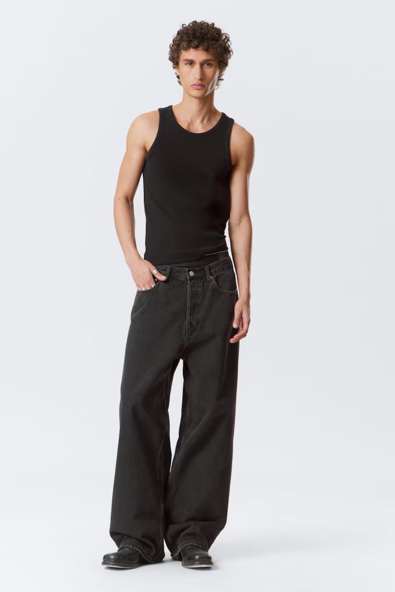 Person wearing a black tank top and black pants on a white background