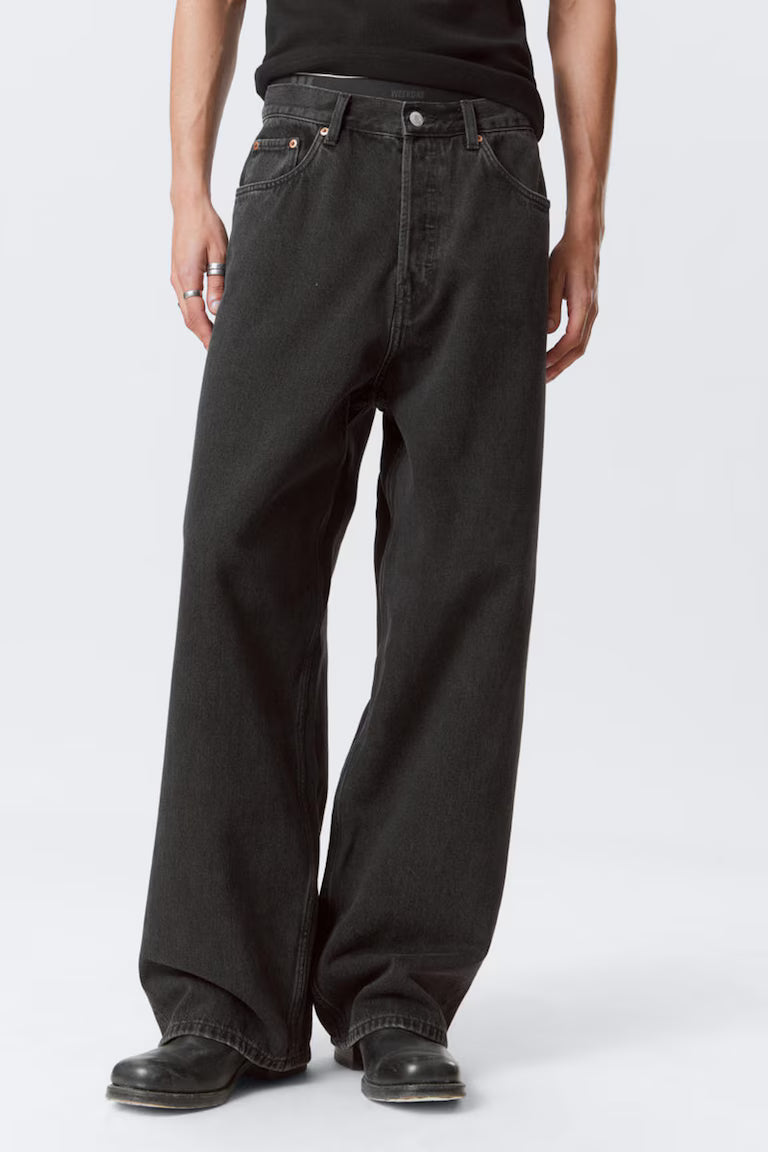 Person wearing black jeans on a white background
