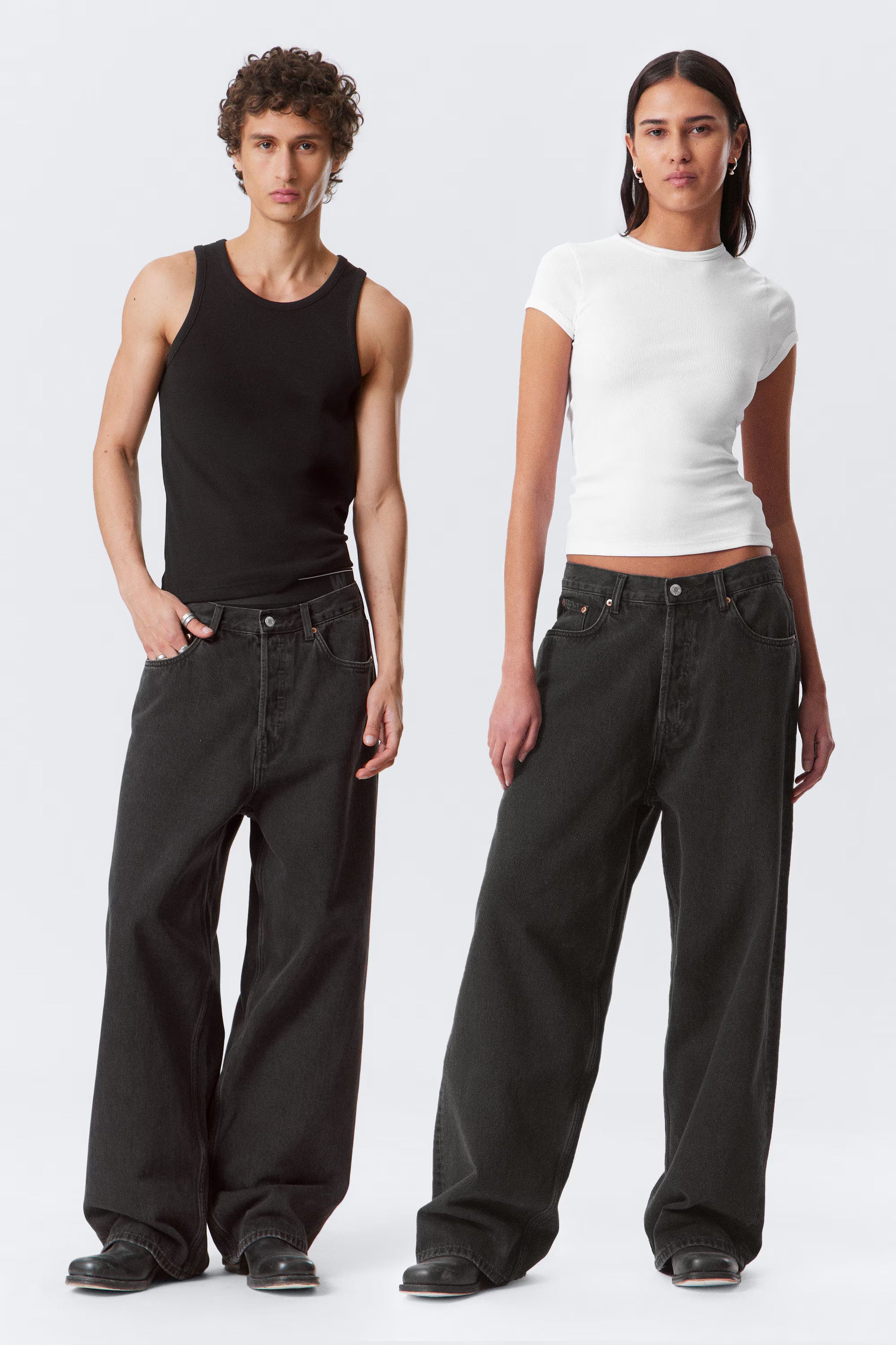 Two people wearing black pants and white tops on a white background