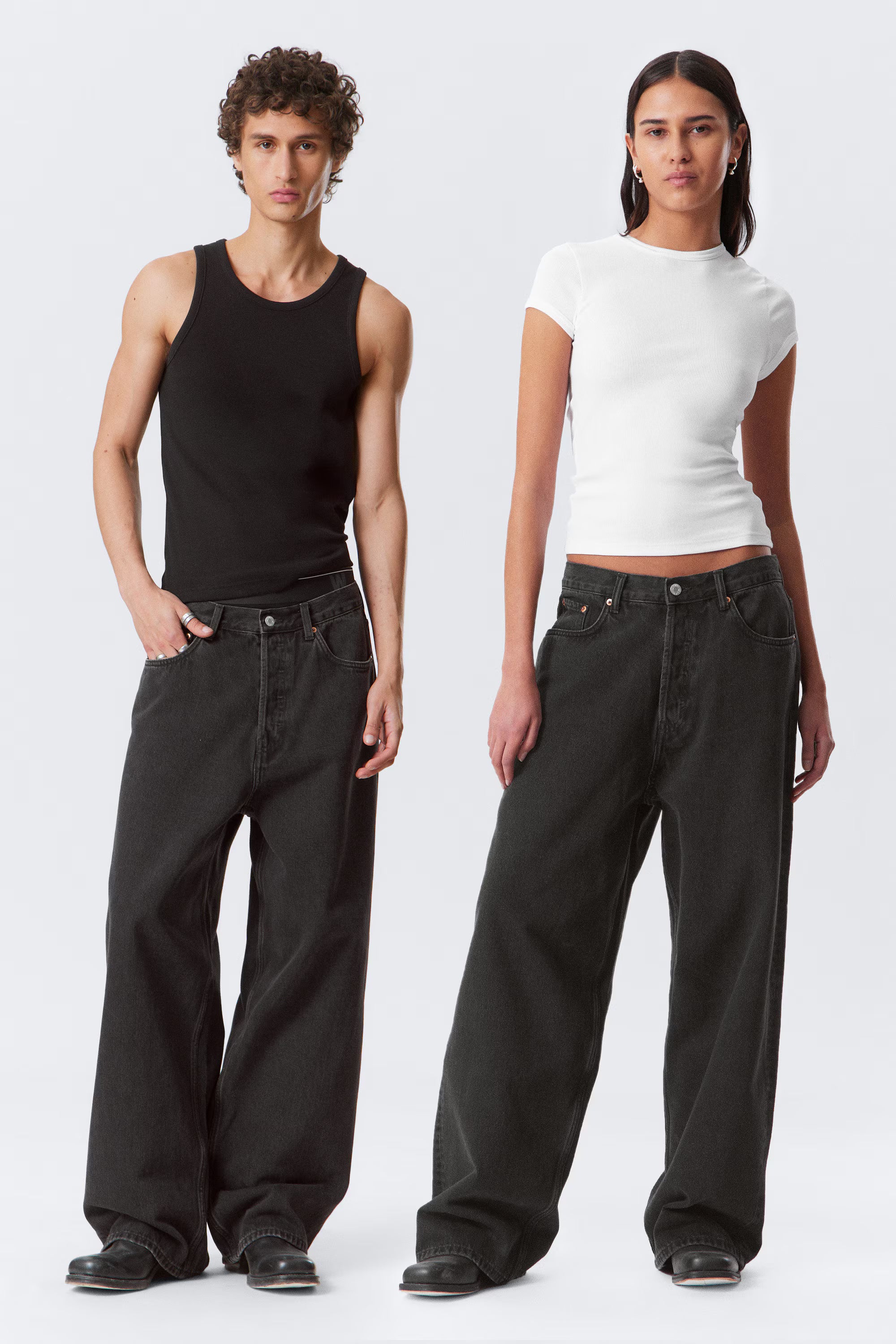 Two people wearing black pants and white tops on a white background