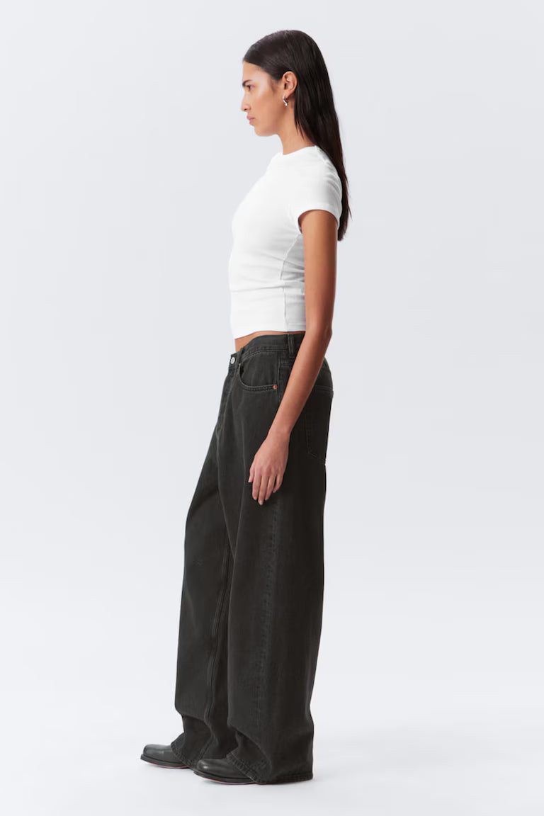 Woman wearing a white top and black pants on a white background